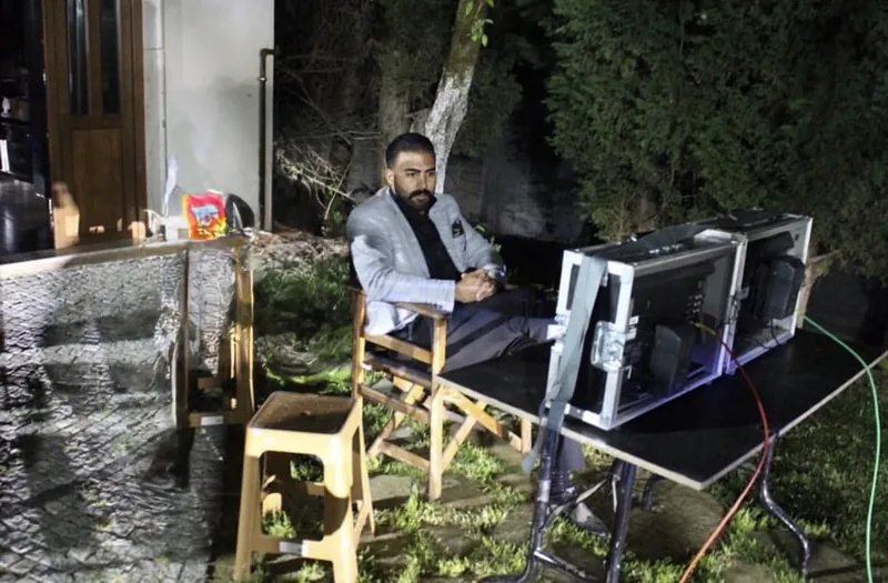 عمر كايا ليلًا في موقع التصوير أمام شاشتي مراقبة