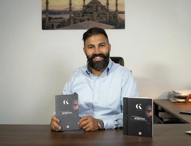عمر كايا إلى مكتبه مع نسختين من كتابه Hayatınızda Keşkelere Yer Vermeyin