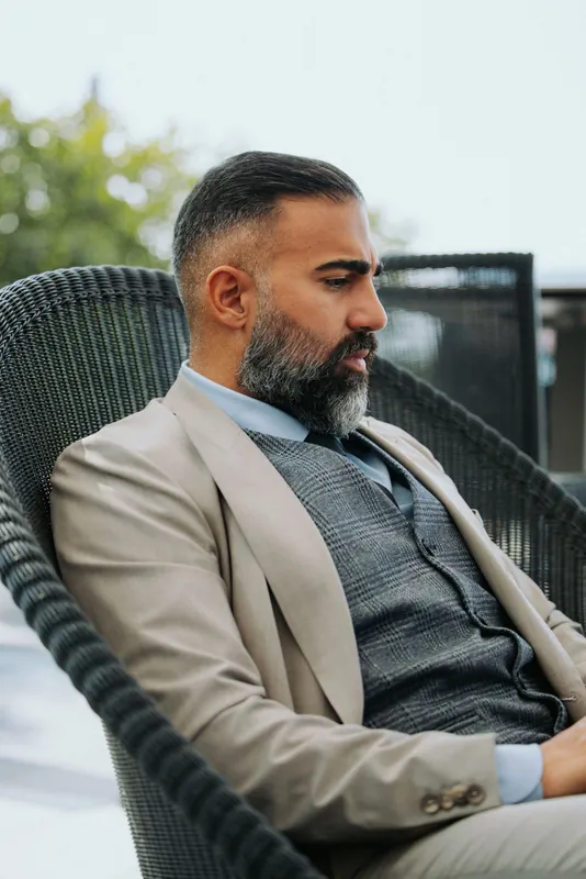 Ömer Kaya im Profil, im beigen Anzug mit grauer Weste