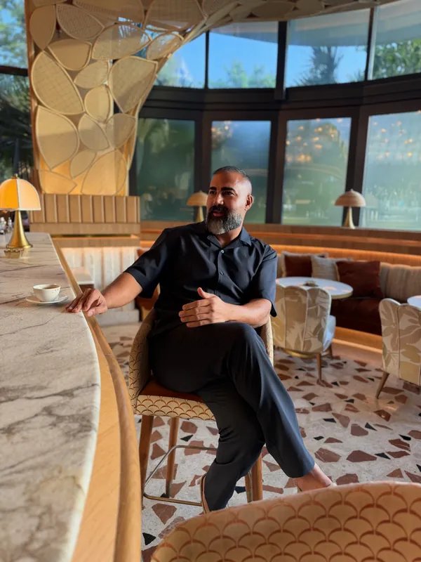 Ömer Kaya an einer Marmorbar in einer Lounge mit hohen Fenstern
